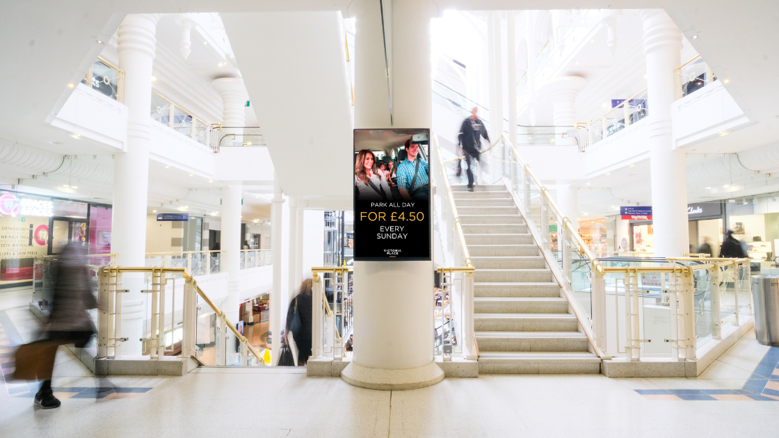 Digital sign in a busy shopping mall that is displaying car parking information to customers